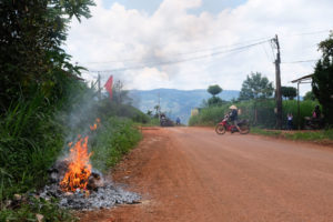 Auf einer kleinen Straße wird Plastikmüll im Feuer verbrannt.